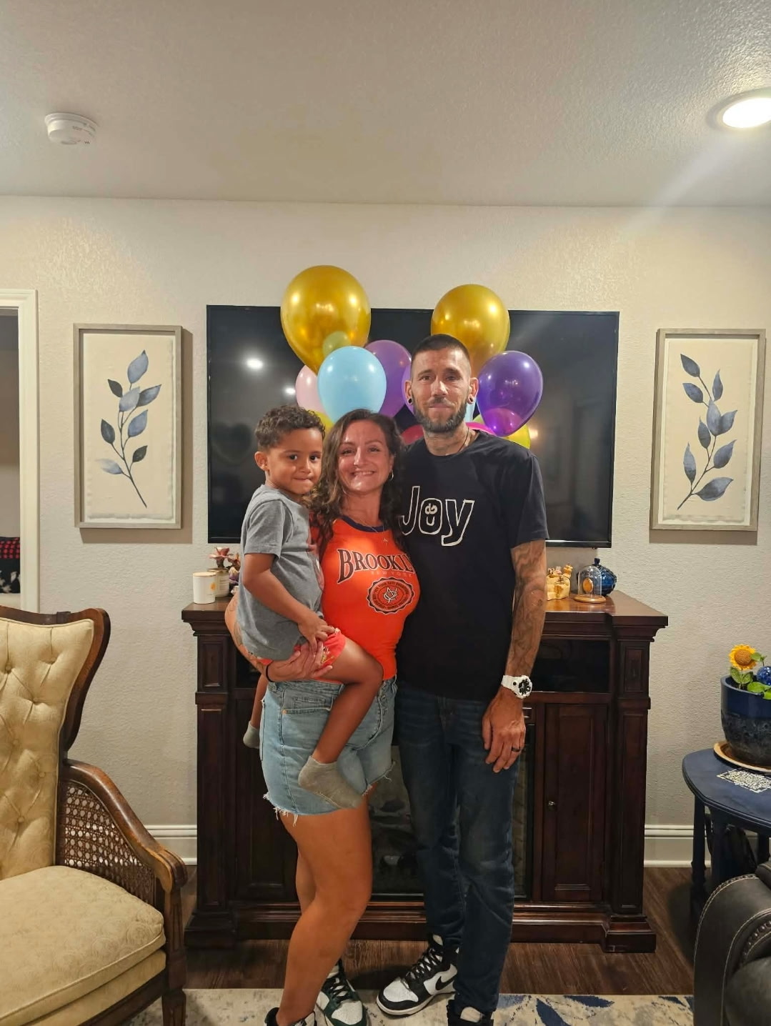 Doug, Ka’lun, and Kaisaiah together beneath colorful balloons